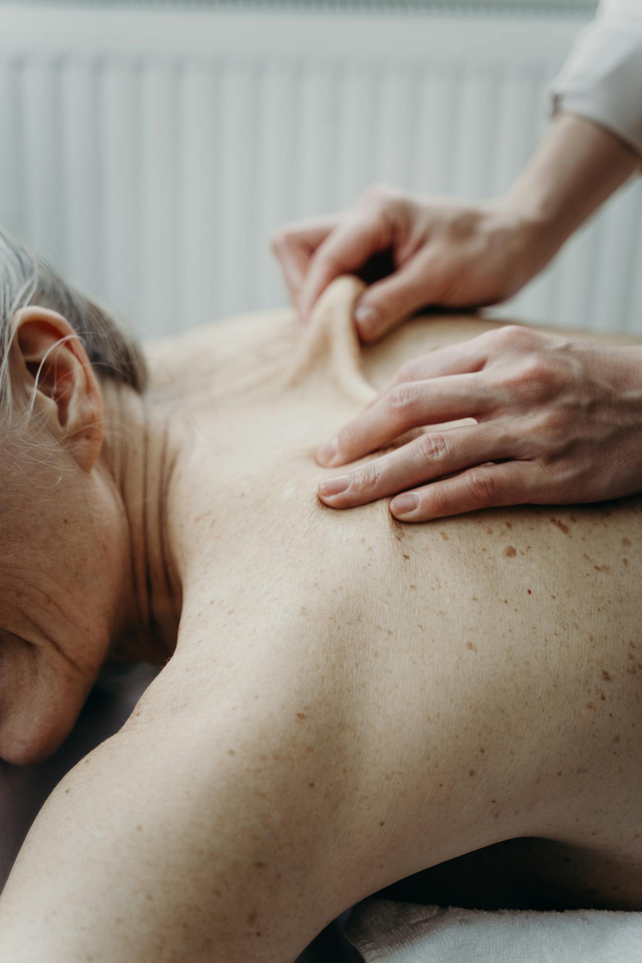 An older client is comfortably and safely positioned with ample pillow support for a geriatric massage.