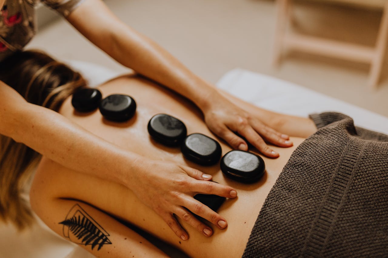 Heated stones are placed along the spine to promote deep relaxation during a hot & cold massage therapy.