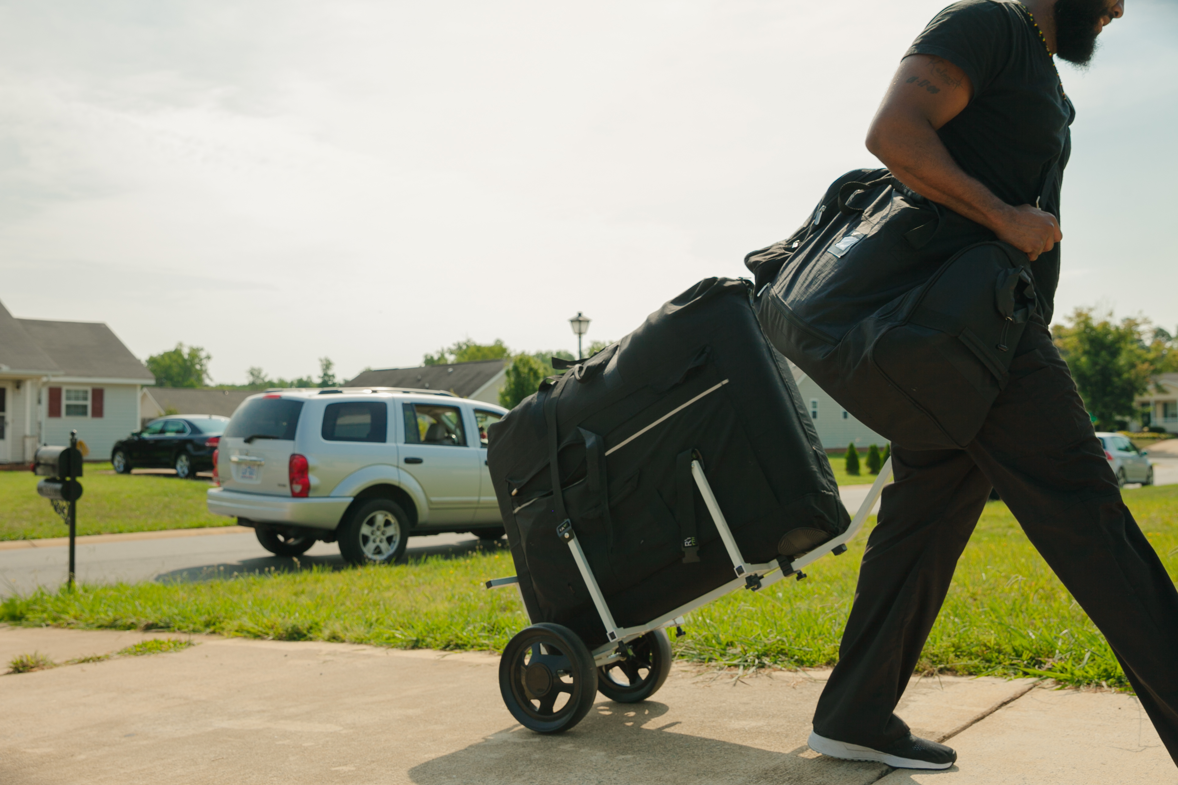 A mobile massage therapist arrives at a client's home with all necessary equipment during a mobile massage session.