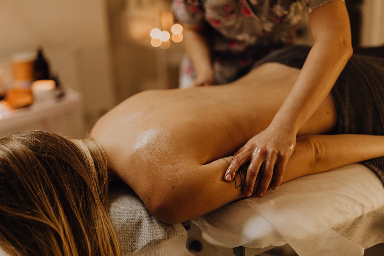 A new mother rests peacefully during a nurturing postnatal massage, embodying relaxation and self-care.